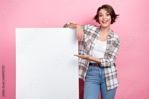Photo of excited funky woman dressed plaid shirt showing hand arm poster empty s Fototapet