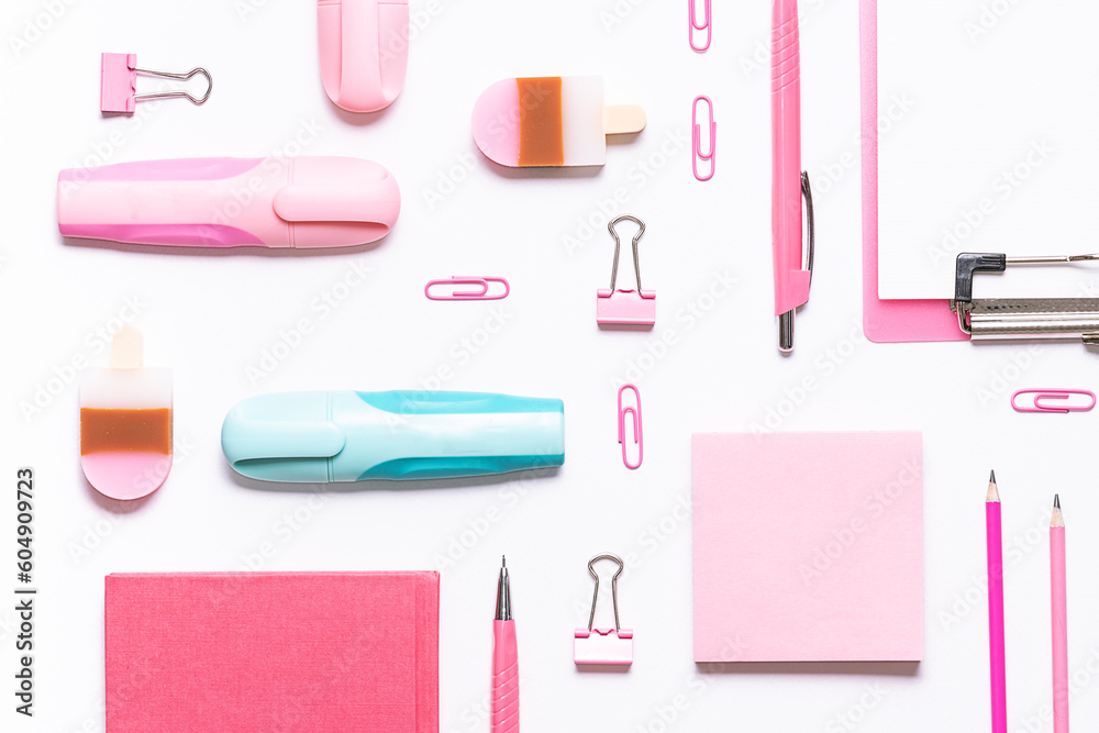 Pink stationery set on white background and one blue marker pen top view. Concept of difference.