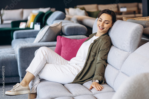 Woman sitting on a new sofa in a furnire store