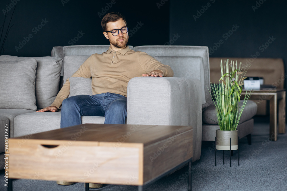 Fototapeta premium Man in furniture store choosing sofa