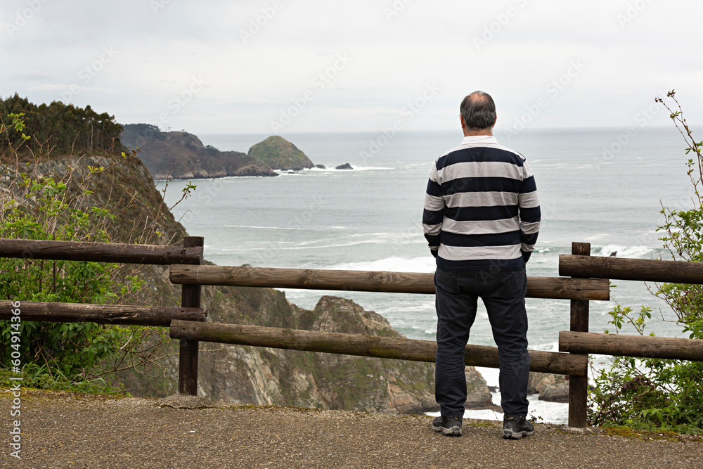 Hombre viendo el paisaje de un acantilado en Asturias, España. Hombre viendo el paisaje de un acantilado en Asturias, España.