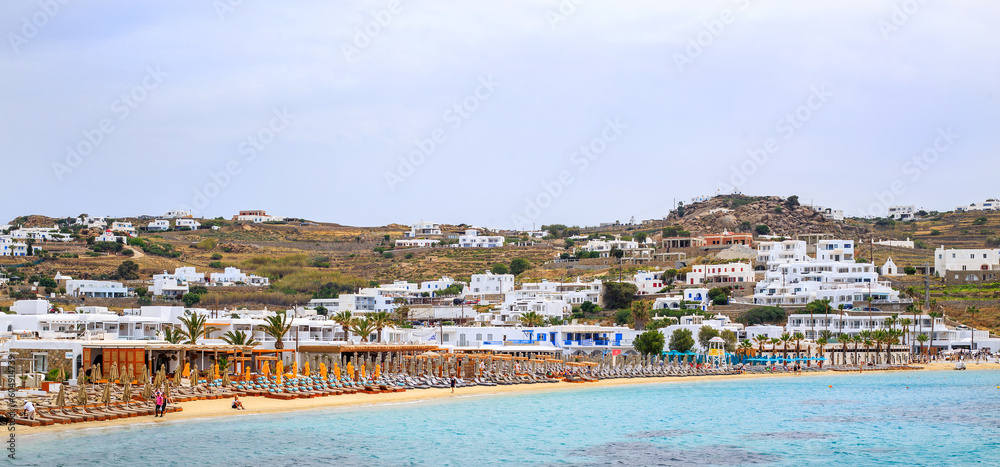 Ornos Beach - Mykonos - Greek island, May 2023.  Beautiful sandy beach with lots of parasols for tourists to use. 
