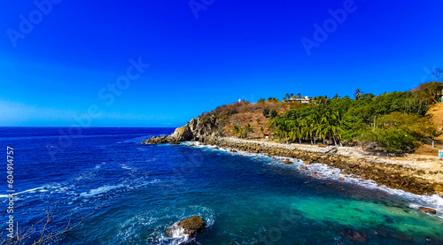 Fototapeta Naklejka Na Ścianę i Meble -  Surfer waves turquoise blue water rocks cliffs boulders Puerto Escondido.