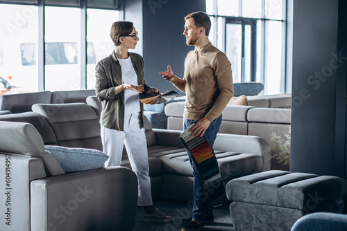 Woman and man designer with textile swatches and wooden palette at furniture store