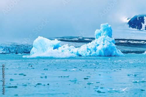 Iceberg floating by a glacier on Svalbard