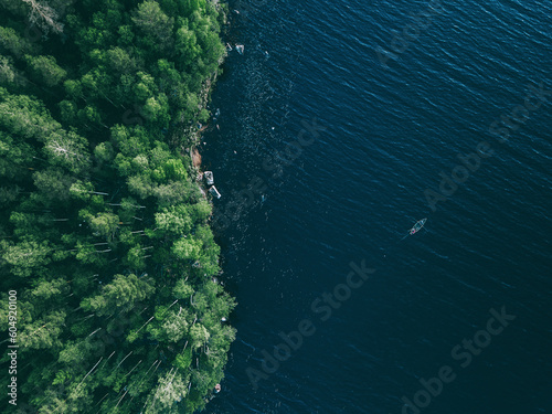 Aerial view fishing boat in blue lake and green woods in Finland