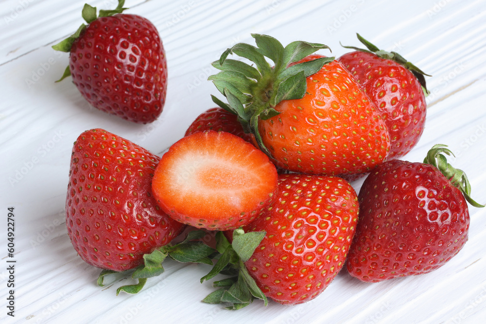 Close-up, texture and background of red ripe, freshly picked strawberries in summer on a wooden white table. Selective focus Close-up, texture and background of red ripe, freshly picked strawberries in summer on a wooden white table. Selective focus