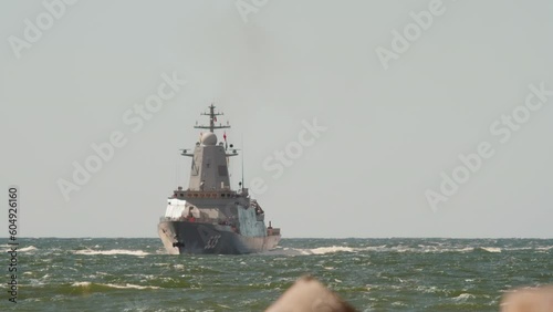 Long shot of antisubmarine missile cruiser, military ship with Russian flag enters the harbor after the duty in the open sea photo