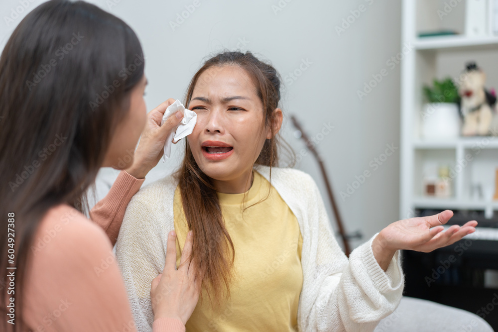Two women talking about problems at home. Asian women embrace to calm their sad best friends from feeling down. Female friends supporting each other. Problems, friendship, and care concept Two women talking about problems at home. Asian women embrace to calm their sad best friends from feeling down. Female friends supporting each other. Problems, friendship, and care concept