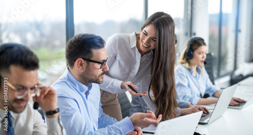 Foto Businesswoman providing supervision to call center employees in an office