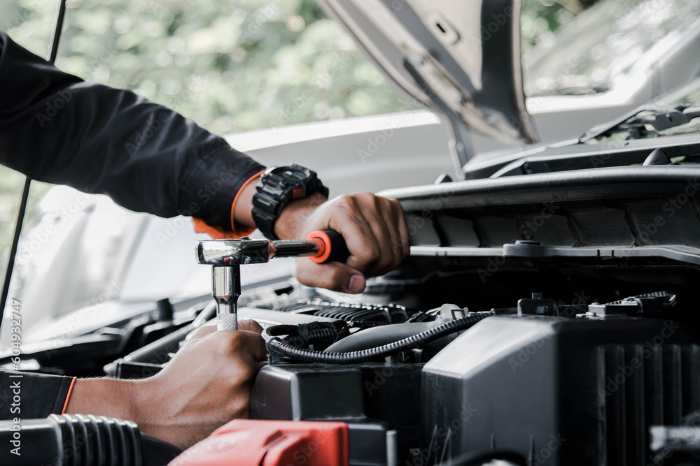 Mechanic fixing a car at home. Repair and service.