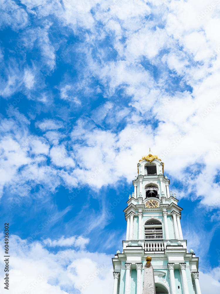 belfry of orthodox church under white clouds in blue sky