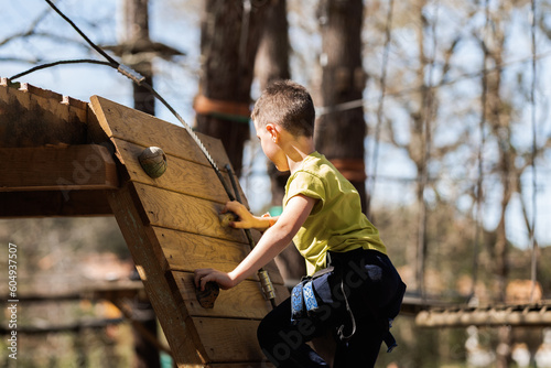 Focused boy on climbing wall in rope park