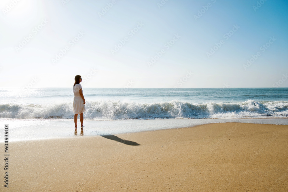 Young asian woman relaxing on the beach at sunrise. Young asian woman relaxing on the beach at sunrise.