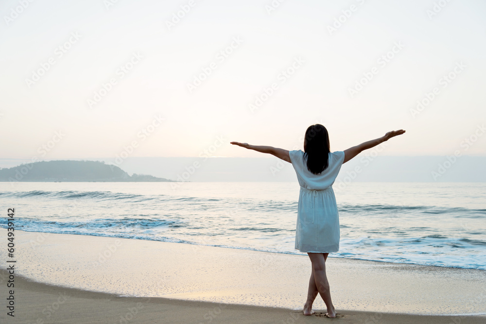 Happy woman standing on the beach with hands up. Happy woman standing on the beach with hands up.