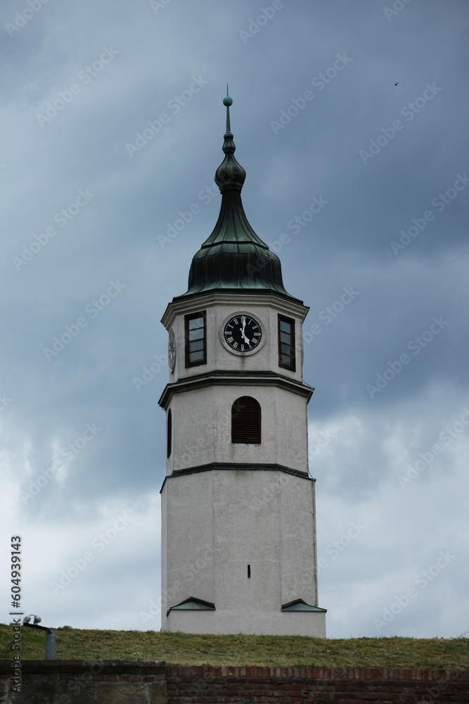 Clock tower, green pointed roof, blue cloudy sky in background