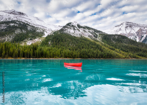 Red canoe floating on Maligne Lake with Rocky Mountains in Jasper national park