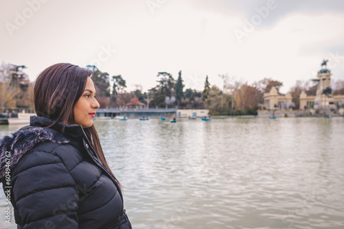Young woman looking at the horizon next to a lake © Sebastian Valencia P
