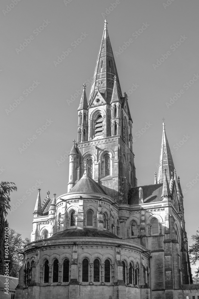 The tall Gothic spire of an Anglican church in Cork, Ireland. Neo-Gothic Christian religious architecture. Cathedral Church of St Fin Barre, Cork - One of Ireland’s Iconic Buildings. Black and white.