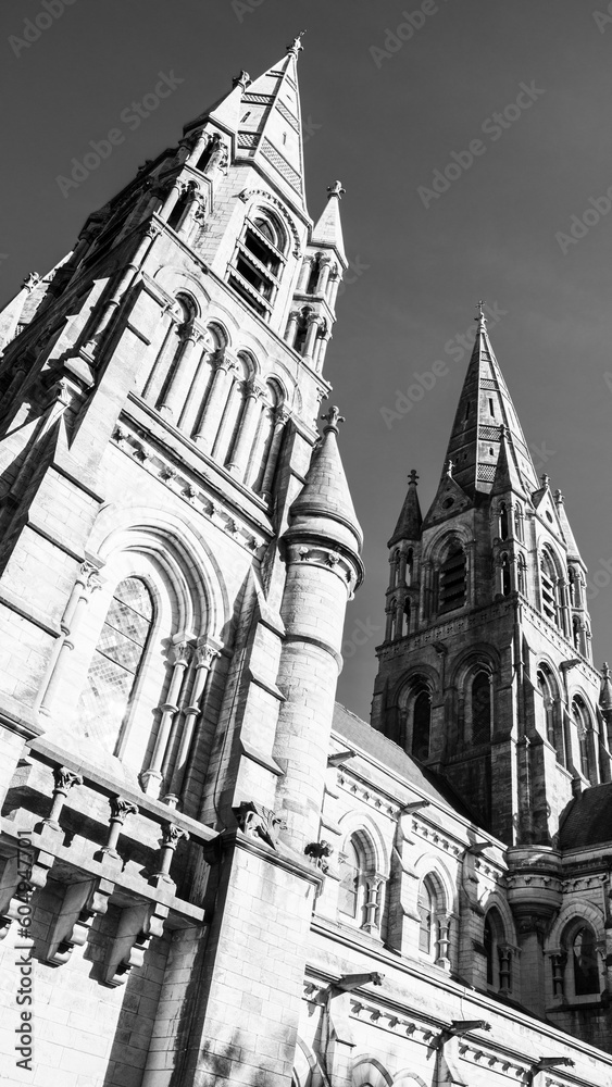 The Gothic spire of an Anglican church in Cork, Ireland. Neo-Gothic Christian religious architecture. Cathedral Church of St Fin Barre, Cork - One of Ireland’s Iconic Buildings. Monochrome.