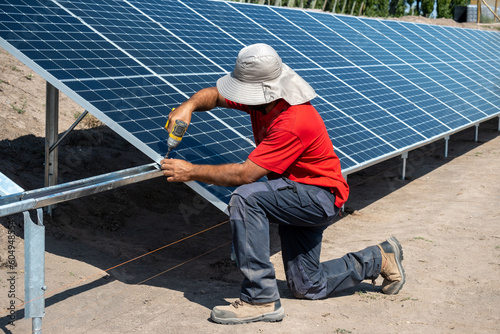 Man's hands putting solar panels, for agricultural irrigation.