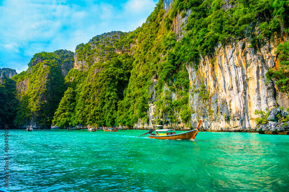 Obraz premium View of Pi Leh lagoon (also known as Green Lagoon) at Ko Phi Phi islands, Thailand. View from typical long tailed boat. Typical Thai picture of tropical paradise. Limestone rock and turquoise water.