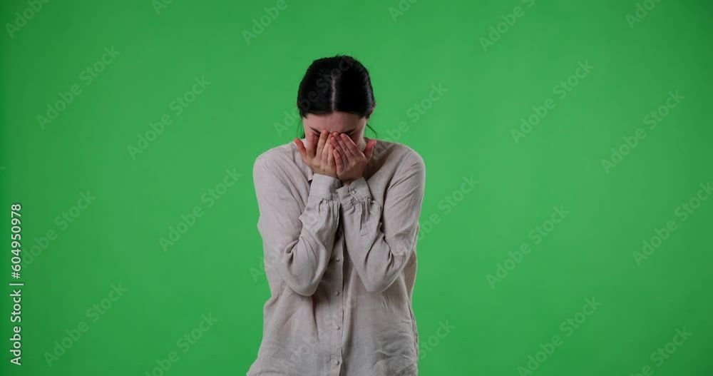 Caucasian woman crying alone on a green screen background. Her tears and sorrowful expression convey feelings of isolation, sadness, and heartbreak. He fell depression, grief, loneliness. Caucasian woman crying alone on a green screen background. Her tears and sorrowful expression convey feelings of isolation, sadness, and heartbreak. He fell depression, grief, loneliness.
