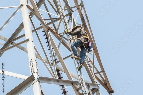 lineman climbing on electrical transmission line tower