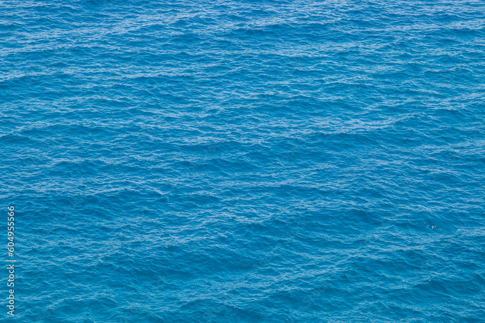 Aguas azules profundas en un día soleado de verano. Superficie ondulada de agua de mar observada desde la parte superior de Ciolo de Gagliano del Capo, Puglia, Italia. - obrazy, fototapety, plakaty 