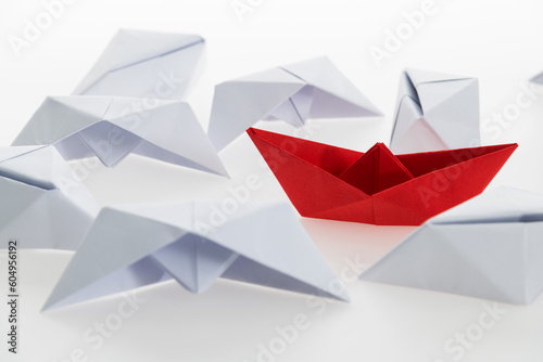 Red paper boat and a lot of sinking ships