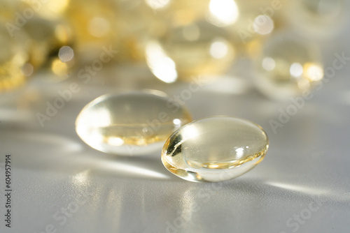 Fish Oil Omega 3 on white background, vitamin D yellow supplement gel capsules, macro shot 