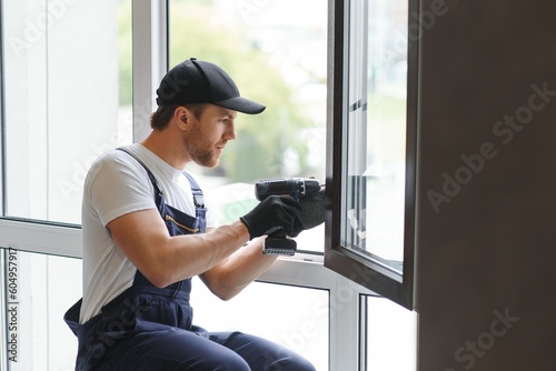 Construction worker installing window in house