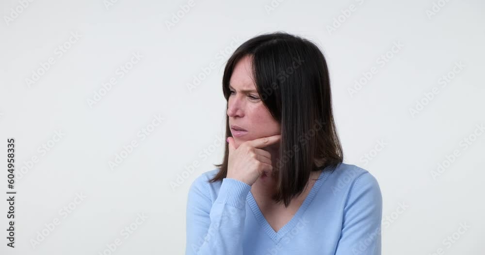 Caucasian woman stands on a white background, she looks around, searching for inspiration and have a brilliant, she raises her hand with a thumbs up gesture, signifying success and satisfaction. Caucasian woman stands on a white background, she looks around, searching for inspiration and have a brilliant, she raises her hand with a thumbs up gesture, signifying success and satisfaction.