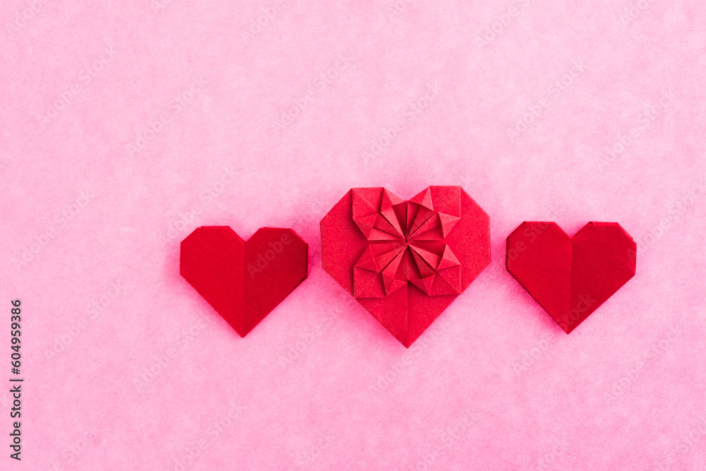 Red origami hearts on pink background. Red origami hearts on pink background.