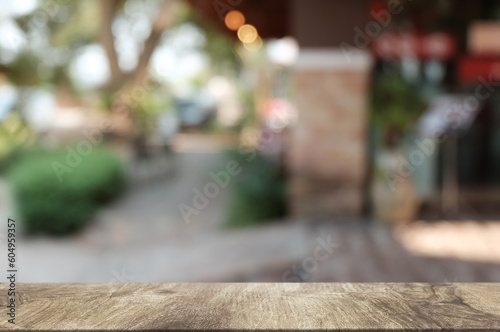 Empty dark wooden table in front of abstract blurred boken bankground of restaurant. Can used for display or montage your products. Mock up for space.