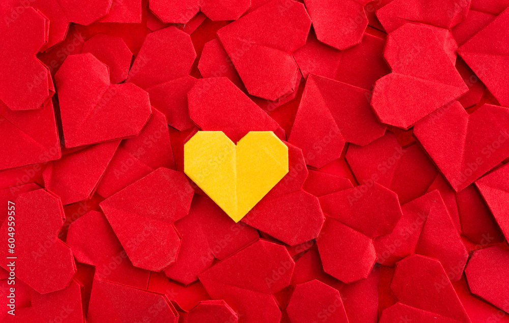 Obraz premium Yellow origami heart on red origami hearts
