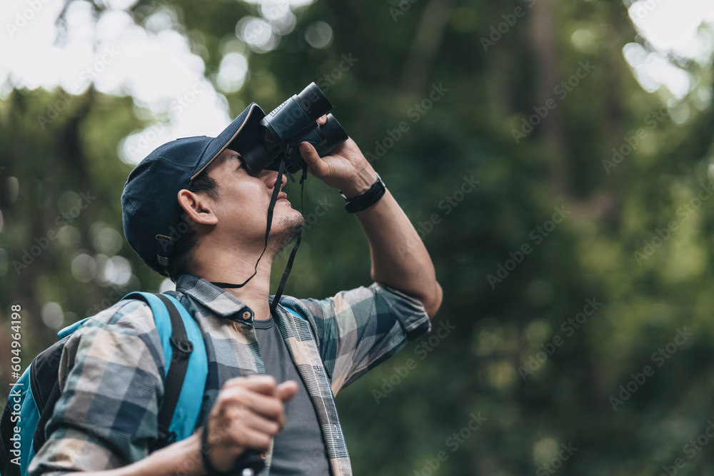 Hikers use binocular to see animals and view landscape  with backpacks in the forest. hiking and adventure concept.