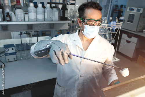 Scientist doing a test in a laboratory muffle in which a sample is calcined in a ceramic crucible. Selective focus