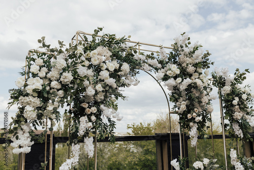 Obraz na płótnie Wedding arch decorated with white flowers and greenery at the wedding ceremony in the fresh air. w salonie