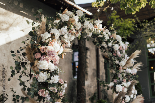 Obraz na płótnie Wedding ceremony with round arch with floral arrangement in the fresh air at summer sunny day.
w salonie