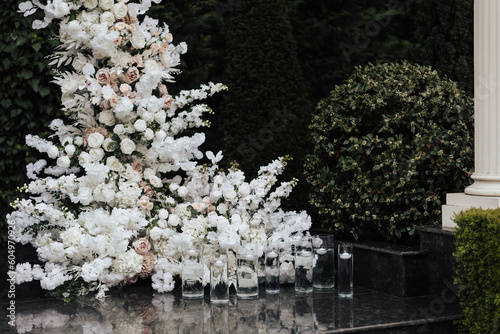 Obraz na płótnie A detail of wedding arch decorated with a composition of white flowers for an outdoor wedding ceremony. Classic wedding decor with candles. w salonie