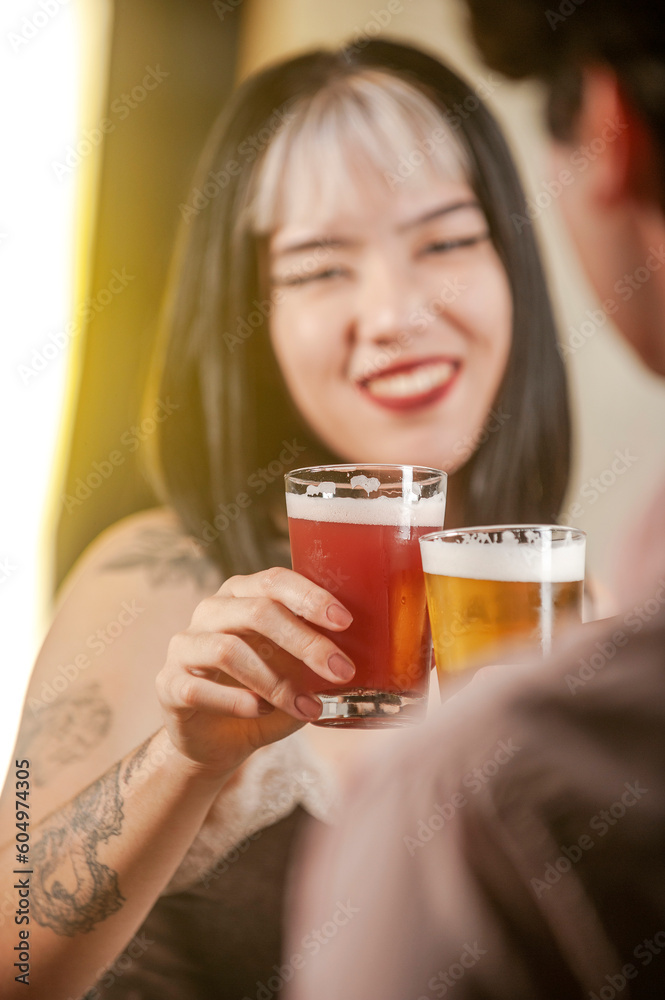 Happy couple toasting with beer at pub restaurant.