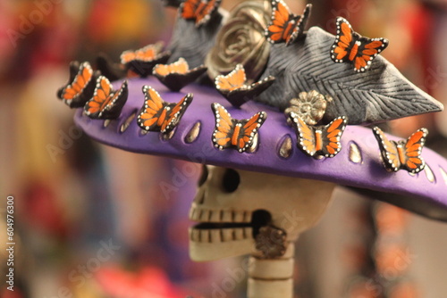 Obraz na płótnie face of a handmade catrina with a hat decorated with traditional monarch butterflies from michoacan w salonie
