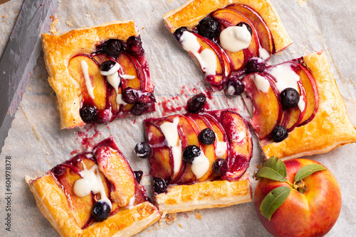 Portions of nectarine and blueberry puff pastry pie with vanilla glaze photo