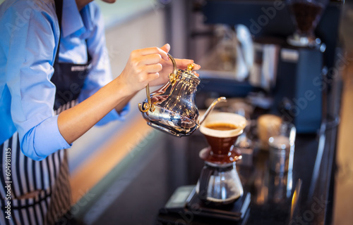 Professional Barista's hand making pouring hot water to coffee drip bag in coffee shop.