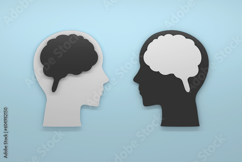 Fototapeta Two human heads with black and white brains in opposition, signifying different communication styles or conflicting perspectives on blue background