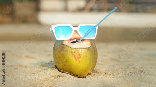 cheerful drinking coconut with plastic straw in its mouth