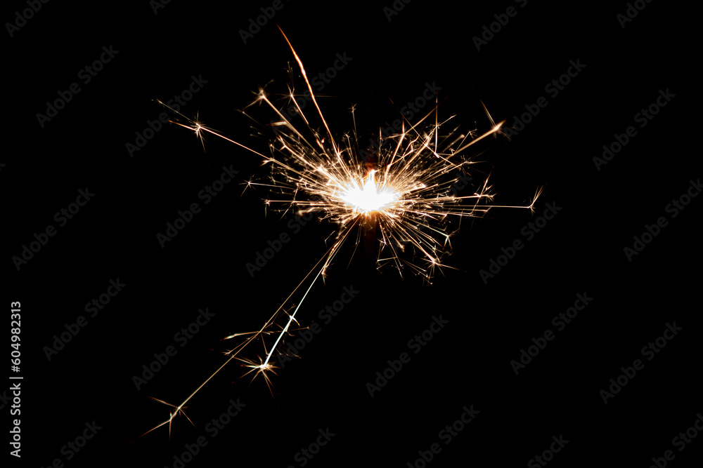Burning sparkler isolated on black background. Fireworks theme. Light effect and texture.