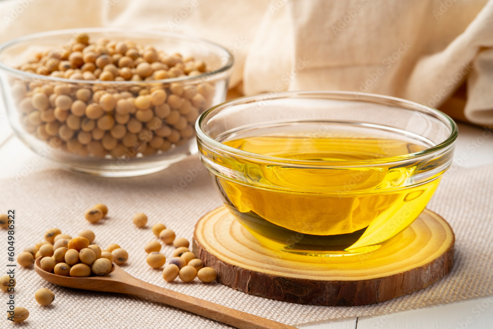 Soybean oil,is a vegetable oil extracted from the seeds of the soybean,in glass bowl on wooden table