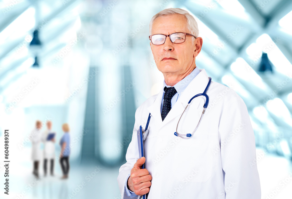 Senior male doctor wearing eyerwear and holding clipboard in his hand Senior male doctor wearing eyerwear and holding clipboard in his hand
